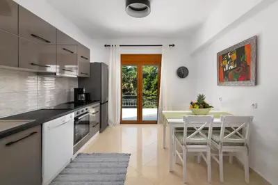 a kitchen with a table and chairs and a dining room at Villa Annatoli in Koskinou