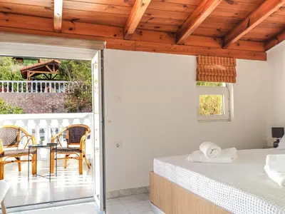 a bedroom with a bed and a table and chairs at Angels beach house in Rhodes Town