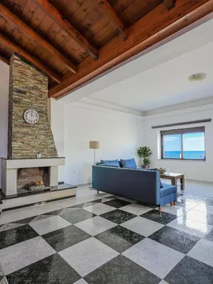 a living room with a blue couch and a fireplace at Angels beach house in Rhodes Town
