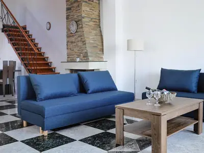 a living room with a blue couch and a table at Angels beach house in Rhodes Town