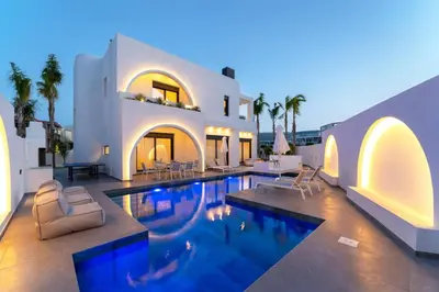 a villa with a swimming pool in front of a house at Villa Palmeras Evelia by Villa Plus in Ialyssos