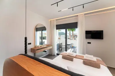 a bedroom with a large bed and a tv at Villa Palmeras Evelia by Villa Plus in Ialyssos