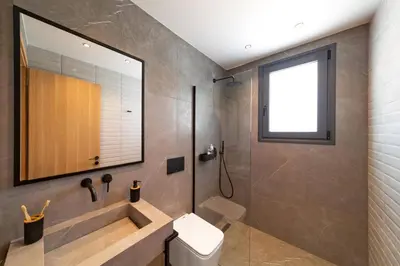 a bathroom with a tub and a toilet and a window at Villa Palmeras Evelia by Villa Plus in Ialyssos