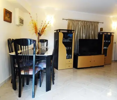 a dining room with a table and chairs and a tv at Nadia's House 2 in Afantou
