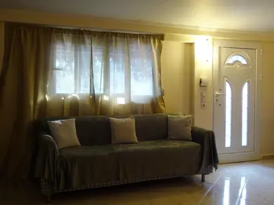 a couch in a living room with a window at Nadia's House 2 in Afantou