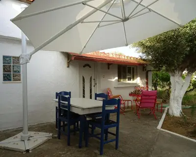 a table and chairs under a white umbrella at Nadia's House 2 in Afantou