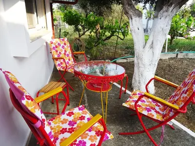 a group of chairs and a table and a tree at Nadia's House 2 in Afantou
