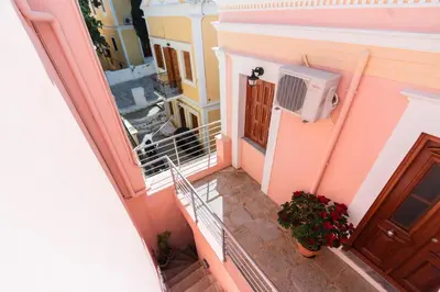 an external view of a balcony of a house with a stairs at YIAYIA's Central Apartment in Symi