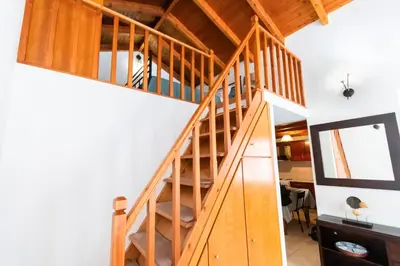 a wooden staircase in a room with white walls at YIAYIA's Central Apartment in Symi