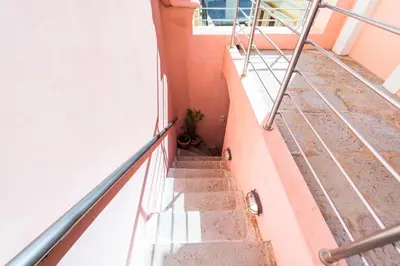 a staircase in a building with a plant at YIAYIA's Central Apartment in Symi