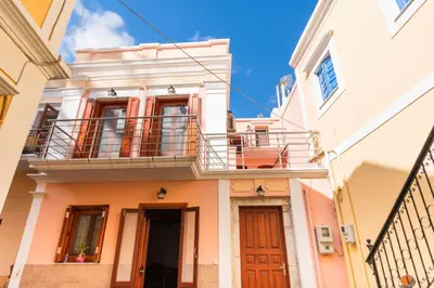 a building with a balcony on top of it at YIAYIA's Central Apartment in Symi