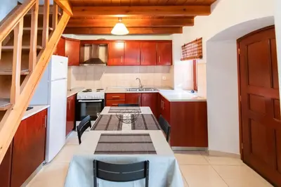 a kitchen with a table and chairs in it at YIAYIA's Central Apartment in Symi