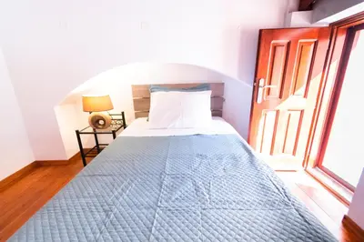 a bed in a room with a large window at YIAYIA's Central Apartment in Symi