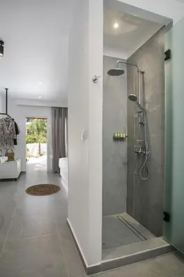 a bathroom with a shower with a glass door at Calma Luxury Studios & Suites in Faliraki