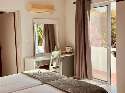 a bedroom with a bed and a desk and a window at Maistrali Hotel & Restaurant in Kalavárda