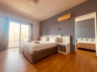 a bedroom with a large bed and a large window at Maistrali Hotel & Restaurant in Kalavárda