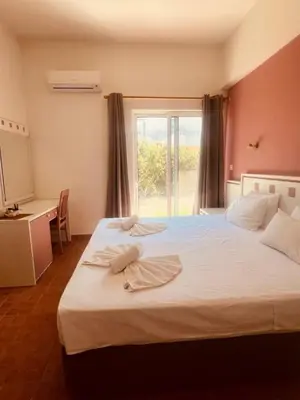 a bedroom with a large white bed with a window at Maistrali Hotel & Restaurant in Kalavárda
