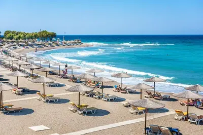a beach with chairs and umbrellas and the ocean at Maistrali Hotel & Restaurant in Kalavárda