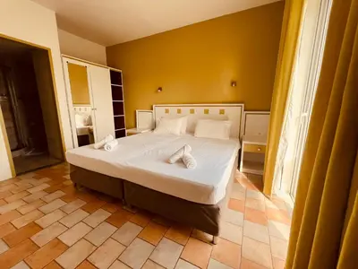 a bedroom with a bed with two towels on it at Maistrali Hotel & Restaurant in Kalavárda
