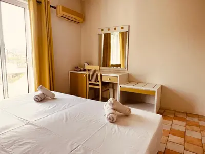 a bedroom with a bed and a desk and a mirror at Maistrali Hotel & Restaurant in Kalavárda