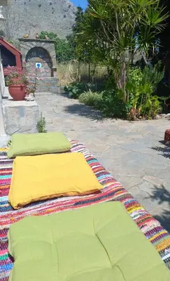 two pillows sitting on a blanket on a patio at Maria's garden house in Archangelos