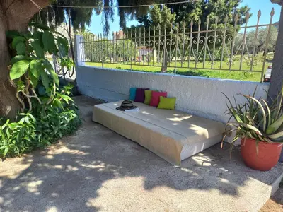 a mattress bed with colorful pillows on it in a garden at Maria's garden house in Archangelos