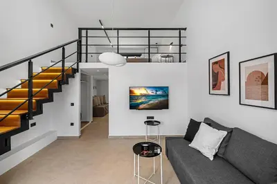 a living room with a couch and a staircase at San Marino Luxury Suites #2 in Asgourou
