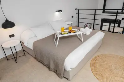 a bedroom with a bed with a tray of food on it at San Marino Luxury Suites #2 in Asgourou