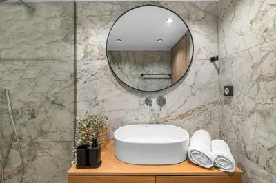 a bathroom with a white sink and a mirror at San Marino Luxury Suites #2 in Asgourou