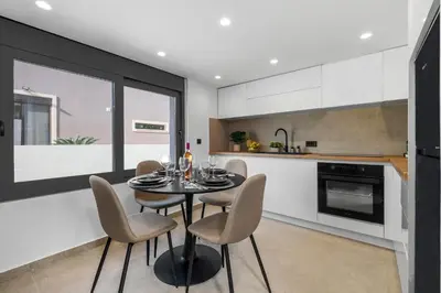 a dining room with a table and chairs in a kitchen at San Marino Luxury Suites #2 in Asgourou