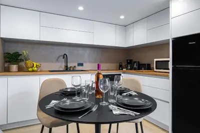 a kitchen with a table with glasses and a bottle of wine at San Marino Luxury Suites #2 in Asgourou