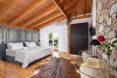 a bedroom with a bed and a stone wall at 4 BD Luxurious villa with swimming pool in Sálakos