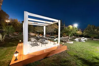 a wooden deck with a table and chairs in a yard at 4 BD Luxurious villa with swimming pool in Sálakos