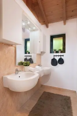 a bathroom with two sinks and two mirrors at 4 BD Luxurious villa with swimming pool in Sálakos