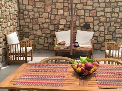 a wooden table with a bowl of fruit on it at Valantina's & Mannouel Lardos Luxury Villas in Lardos