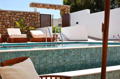 a swimming pool with chairs and a table at Valantina's & Mannouel Lardos Luxury Villas in Lardos
