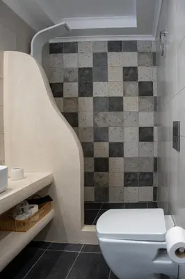 a bathroom with a toilet and a tiled wall at 