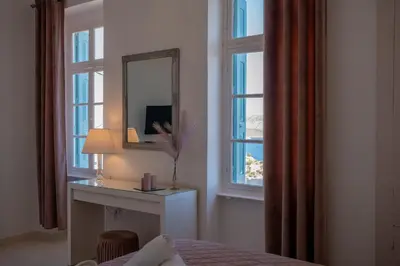 a bedroom with a mirror and a table and window at 