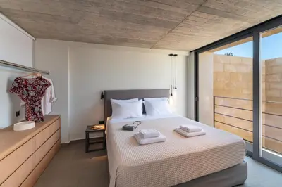 a bedroom with a bed with two towels on it at Linear Cabanon Kallithea Luxury Villas in Koskinou