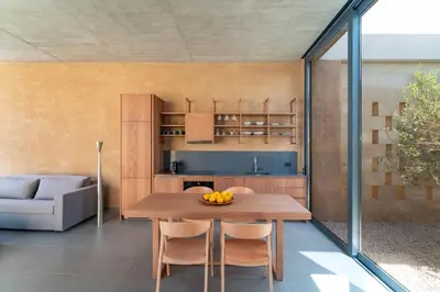 a kitchen and dining room with a wooden table at Linear Cabanon Kallithea Luxury Villas in Koskinou