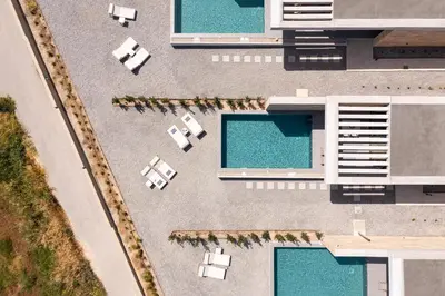 an overhead view of a pool with chairs and tables at Linear Cabanon Kallithea Luxury Villas in Koskinou