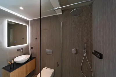 a bathroom with a shower and a toilet and a sink at Linear Cabanon Kallithea Luxury Villas in Koskinou