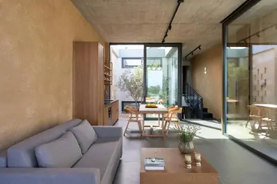 a living room with a couch and a table at Linear Cabanon Kallithea Luxury Villas in Koskinou