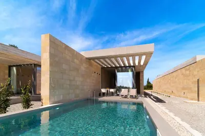 a swimming pool in front of a house at Linear Cabanon Kallithea Luxury Villas in Koskinou