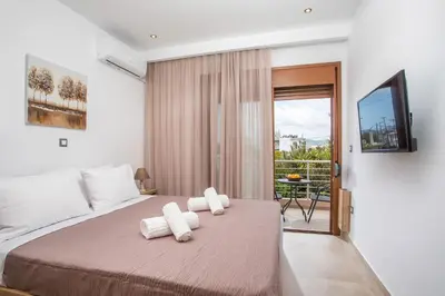 a bedroom with a bed with two towels on it at M&E APARTMENTS New in Haraki