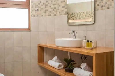 a bathroom with a sink and a counter with towels at M&E APARTMENTS New in Haraki