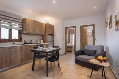 a kitchen and living room with a table and a couch at M&E APARTMENTS New in Haraki