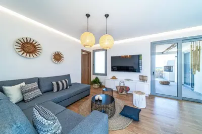 a living room with a blue couch and a tv at Villa Levanta in Gennadi
