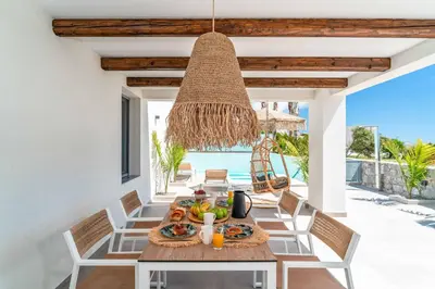 a dining room with a table with food and a chandelier at Villa Levanta in Gennadi