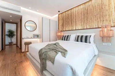 a bedroom with a large white bed and a mirror at Villa Iviskus in Gennadi
